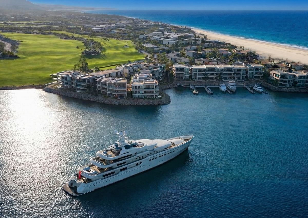 A superyacht at the Costa Palmas marina, with residences, the golf course and the beach behind