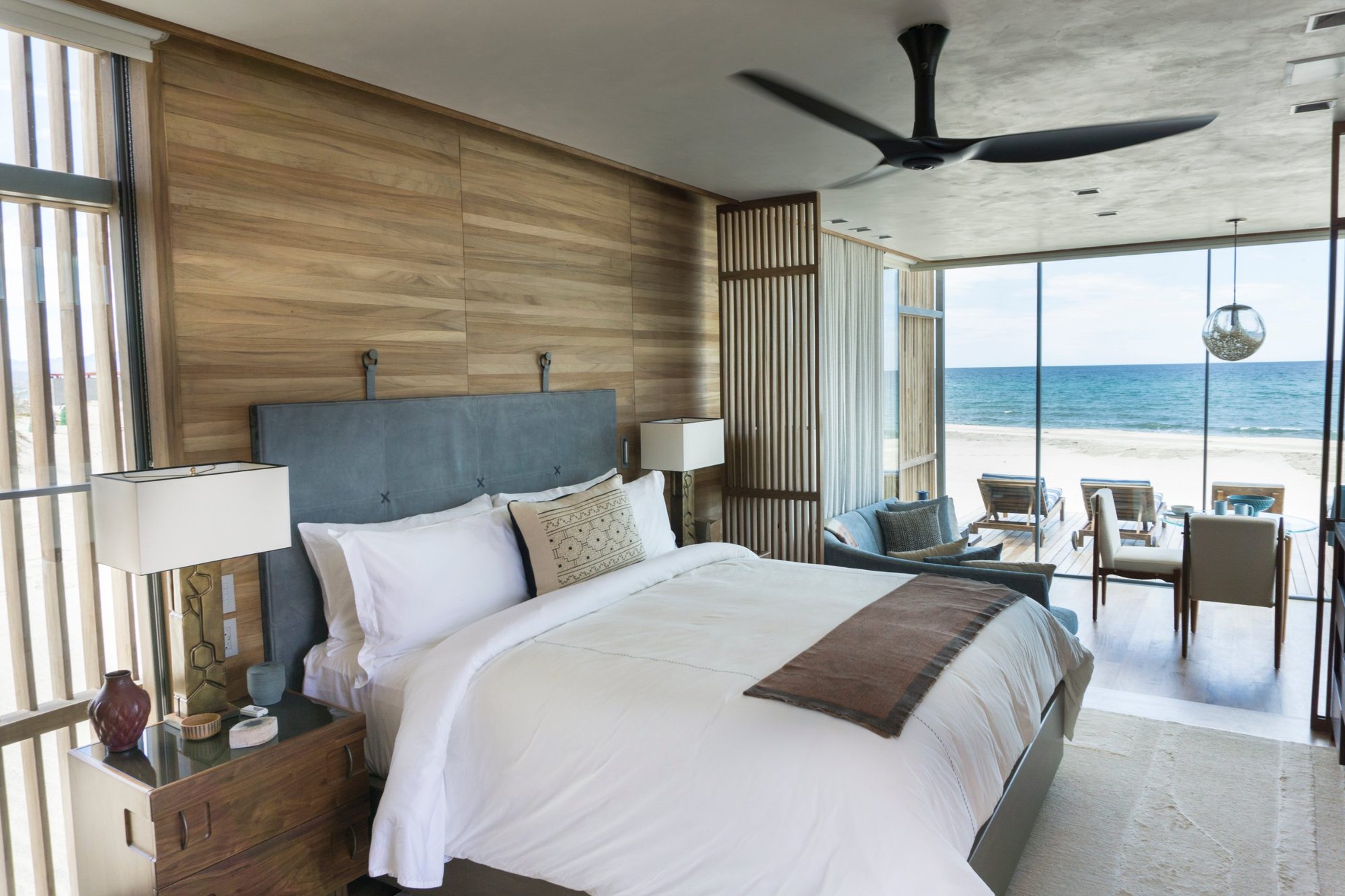 A beachfront cabana bedroom at Costa Palmas, opening onto a deck, the sand and the Sea of Cortez
